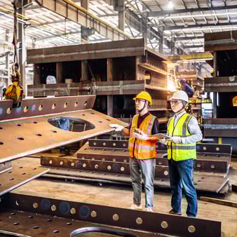 Two employees working in a metal manufacturing plant
