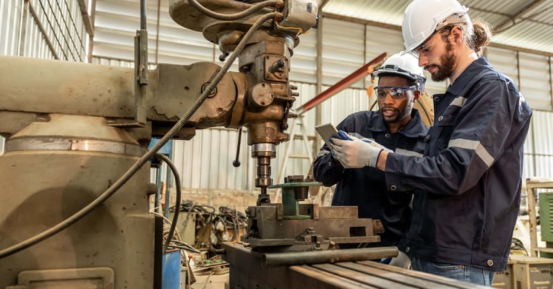 metal workers using a metal milling machine