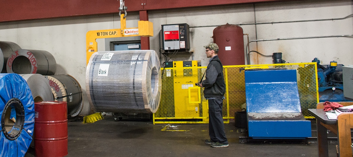 Mead employee moving a coil of steel using a lift