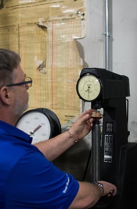 mead metals employee testing the thickness of a material